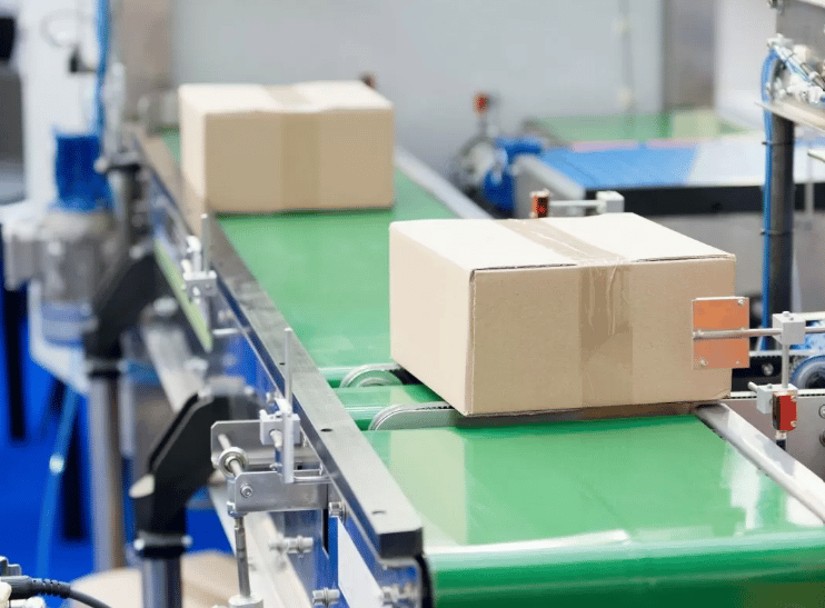 Paketleme alanında bant üzerindeki kapalı karton kutular